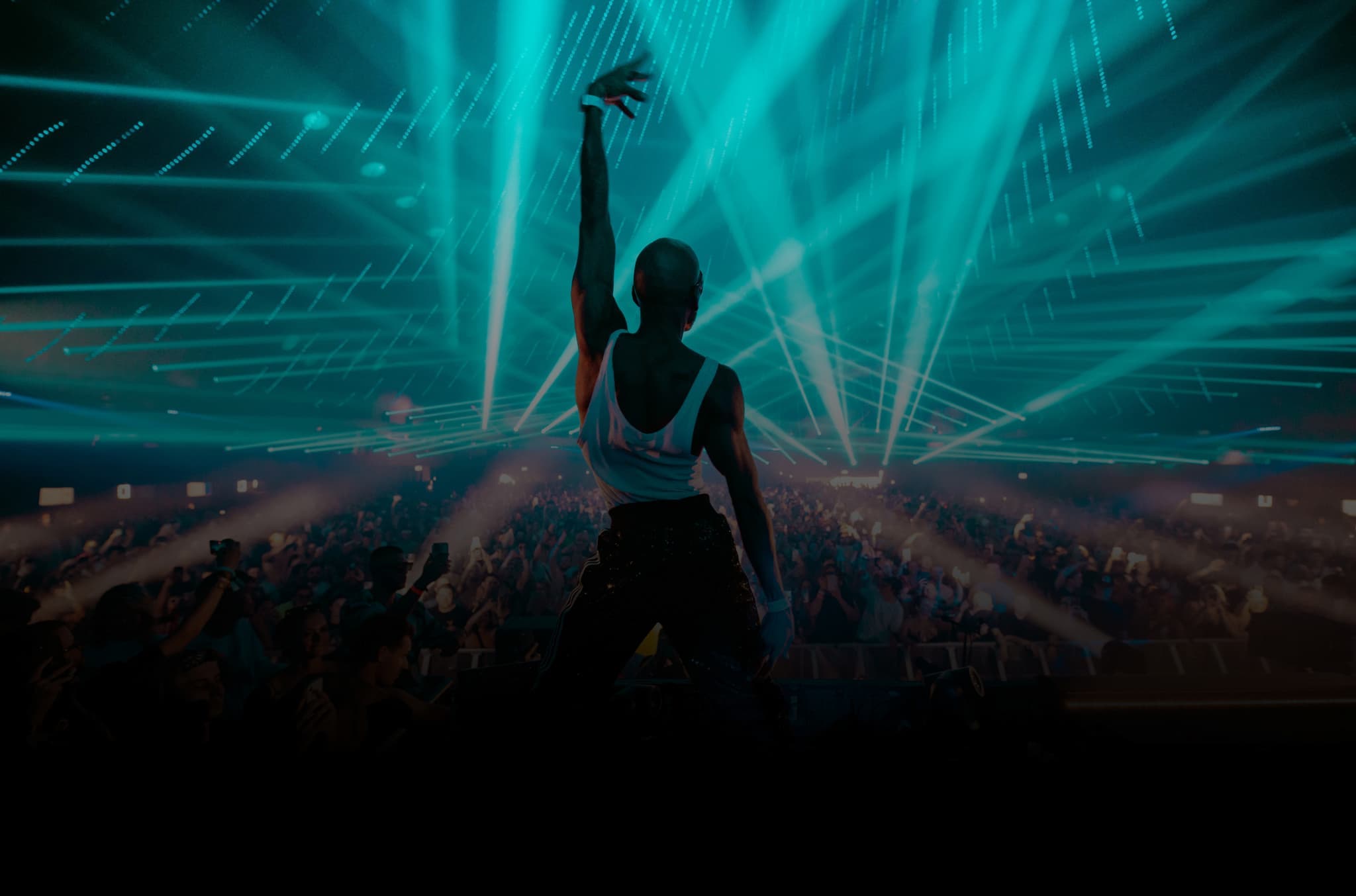 DJ waving her hand in front of the people of tomorrow with a blue laser show